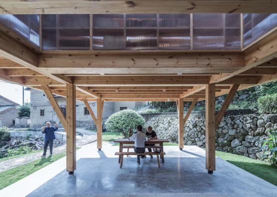 people sitting at a table under a covered patio