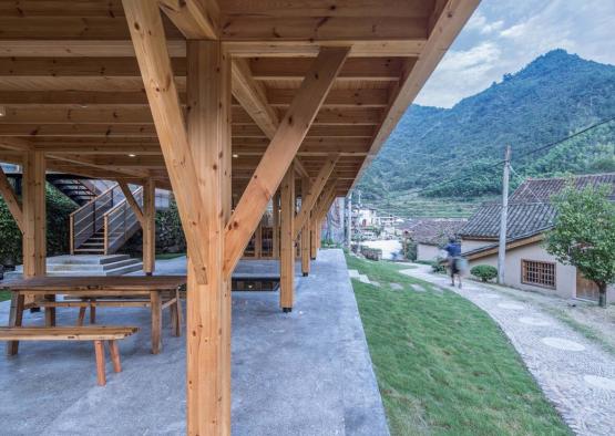 a wooden structure with a hill in the background