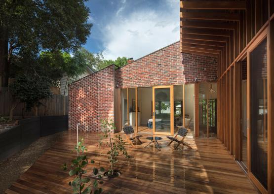 a patio with chairs and a wood deck