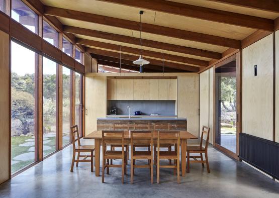 a dining table and chairs in a room with glass walls