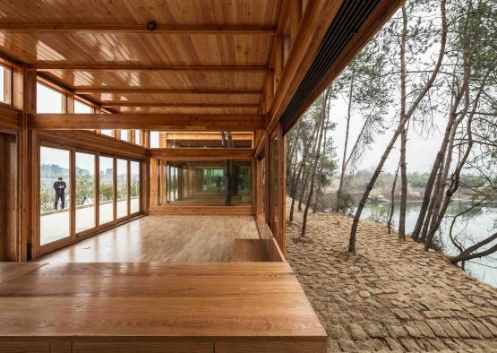 a wooden room with a view of the water and trees
