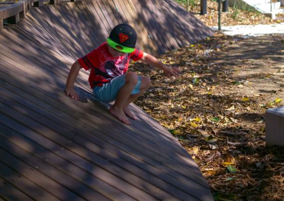 a boy wearing a helmet and sitting on a ramp