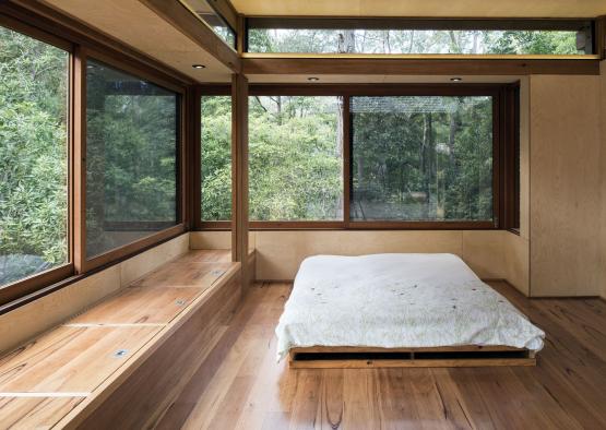 a bed in a room with windows