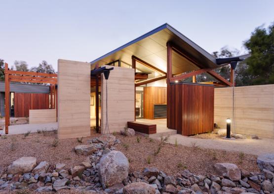 a house with a stone wall and a wooden structure