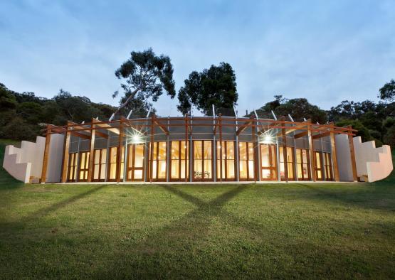 a building with a glass roof and a green lawn