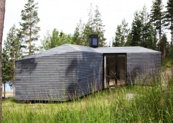 a small gray building in tall grass