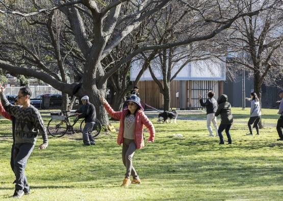 a group of people playing frisbee in a park