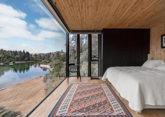 a room with a view of a lake and a bed