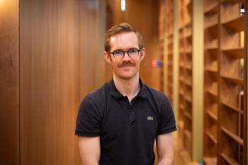 Headshot of man against wooden backdrop