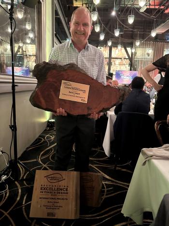 Image of man holding wood cross section award trophy