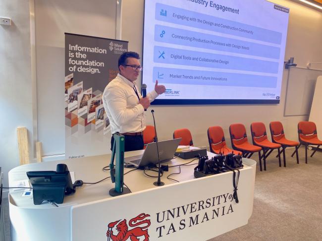 Man giving presentation at University of Tasmania desk