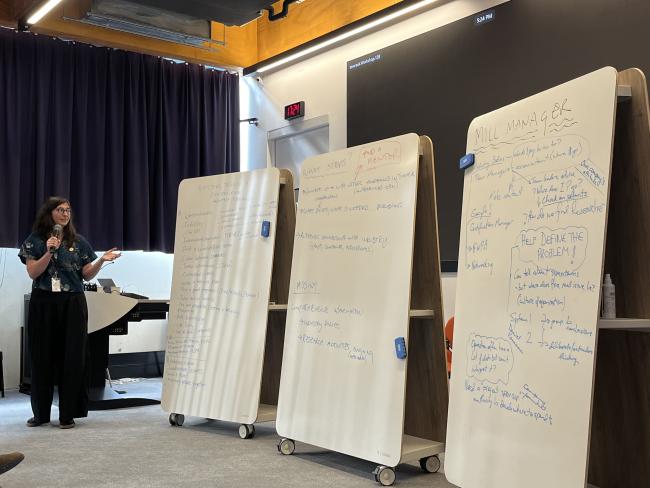 Woman presenting three large whiteboards