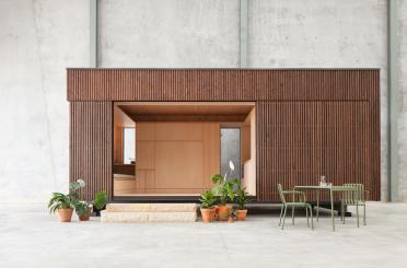 a wooden building with a table and chairs