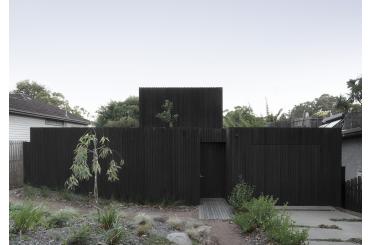 a black fence with a small tree in the back