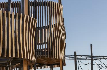 a wooden structure with a rope and a blue sky