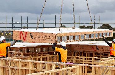 a man in a yellow jacket and white helmet working on a construction site